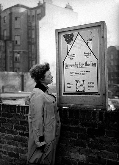 Housewife reads a London borough of Holborn poster
